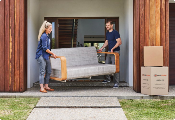 a61671c243acd84e4ea0b063f93e146c A couple moving a couch outside their home
